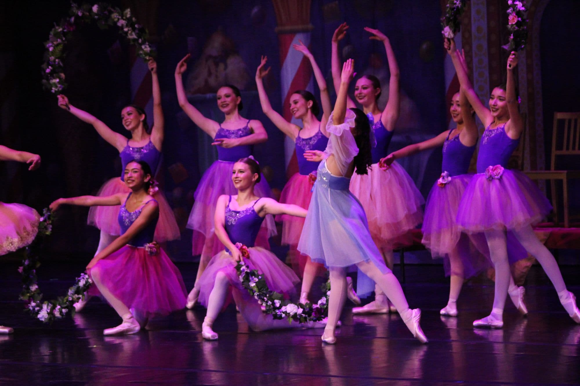 DIDC ballet dancers in purple and pink tutus performing with flower garlands