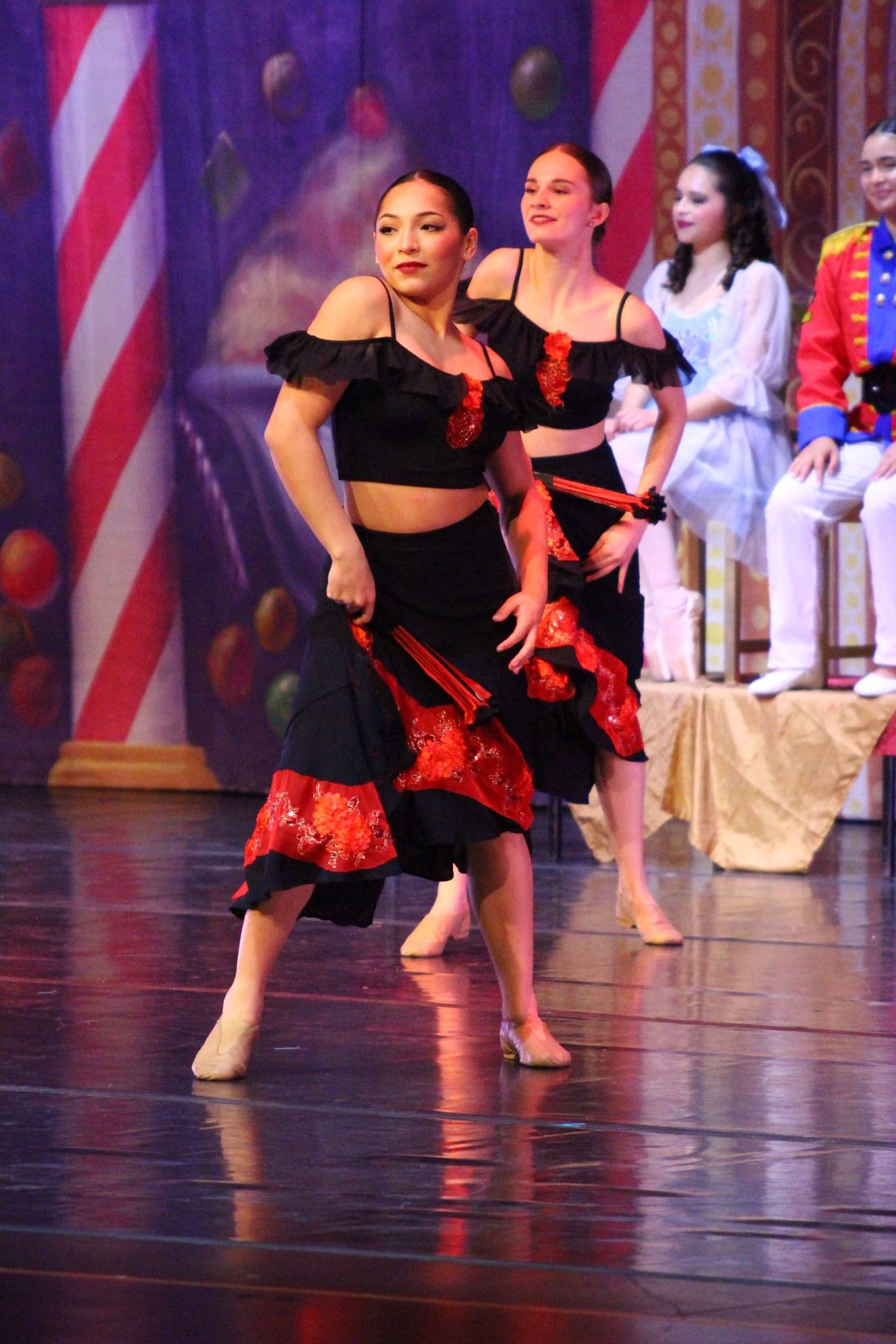 Two DIDC dancers in black and red costumes performing a Spanish variation
