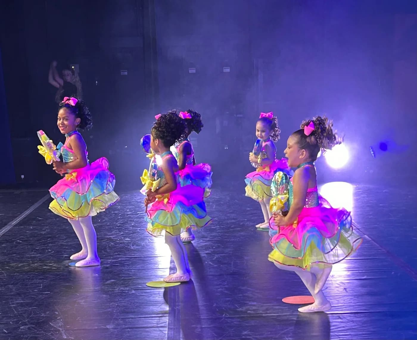 Young DIDC dancers in colorful costumes performing on stage