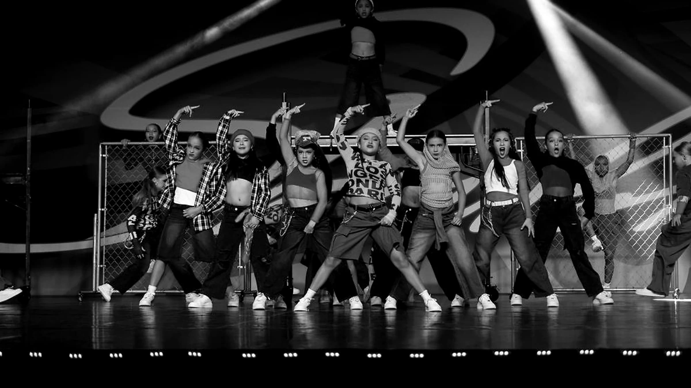 DIDC hip hop dancers mid-performance on stage under bright lights
